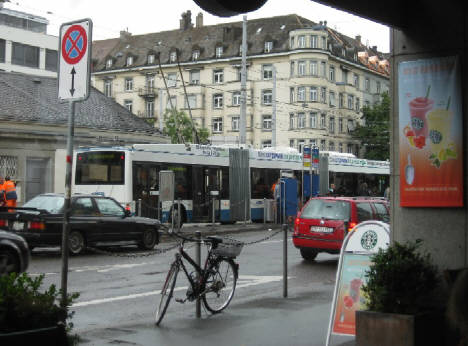 blick vom starbucks coffee shop zum kreuzplatz hinaus. an der tram- und busstation der 31er bus vp, ty hess doppelgelenkbus. 